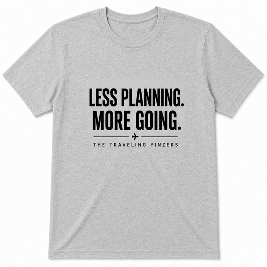 Grey t-shirt with Less Planning More Going bold text and airplane accent by The Traveling Yinzers