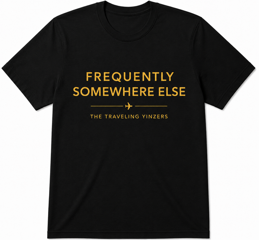 White t-shirt with gold Frequently Somewhere Else text by The Traveling Yinzers